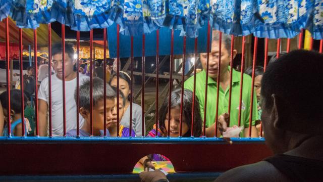 People lining up for tickets for an amusement park ride. 