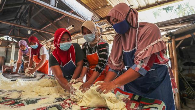 Women making cassava chips in Indonesia.
