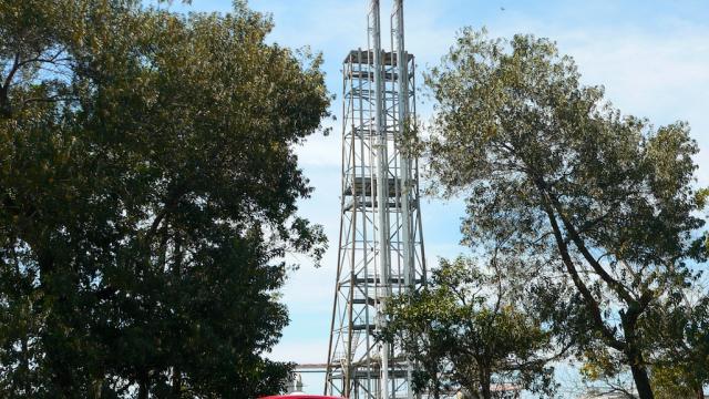 A car is parked near a gas flaring facility in Brunei.